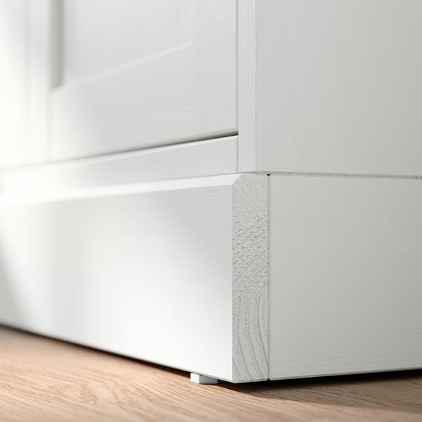 Witte houten kasthoek met getextureerd detail.