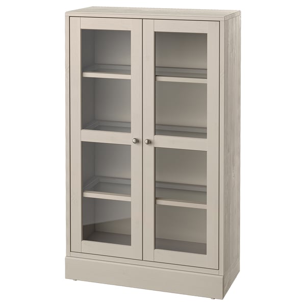 Een lichtgekleurde HAVSTA houten kast met glazen deuren, met een rustiek en toch modern design.