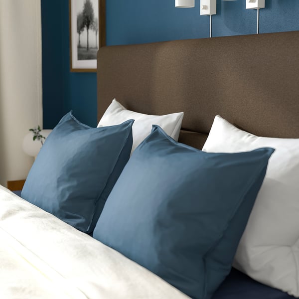 Knus bed met zacht hoofdeinde, witte en blauwe kussens; Verwijderbare hoezen voor eenvoudige schoonmaak.