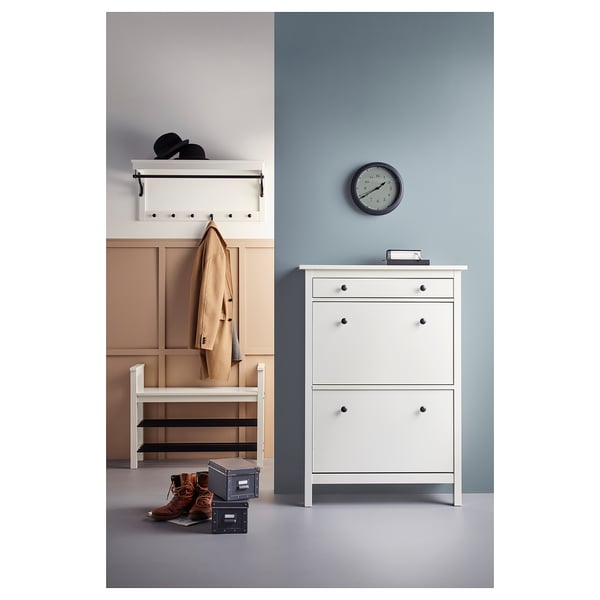 Entreeopstelling met witte HEMNES schoenenkast, haken, jas, laarzen en klok.