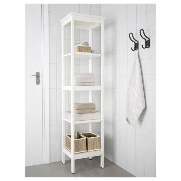 Witte HEMNES badkamerplank, 4 lagen, houdt handdoeken en manden, staat hoog bij de deur.