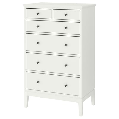 Een witte IDANÄS hoge ladekast met zes lades. Het heeft een klassiek ontwerp met houten knoppen en slanke poten, en biedt voldoende opbergruimte.