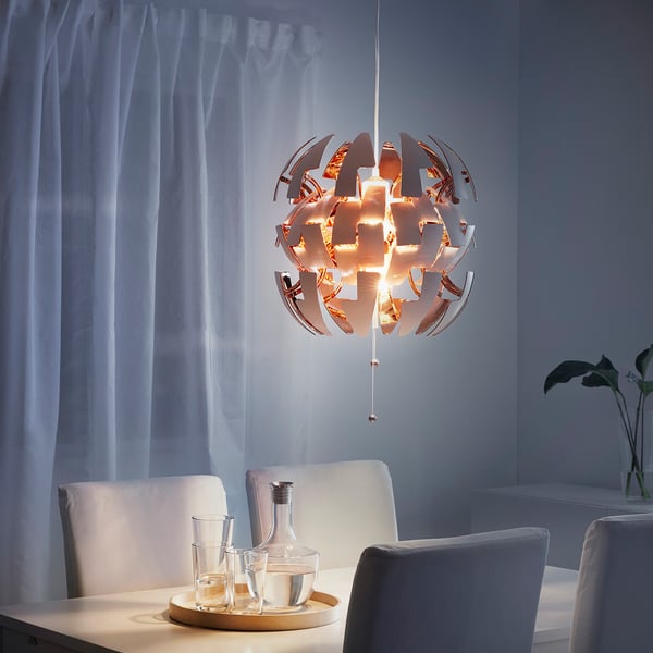 Moderne eethoek met een IKEA PS 2014 hanglamp met instelbare lichtintensiteit en schaduwen met patronen op de muur.