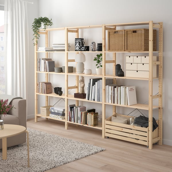 Ivar-rek van natuurlijk hout, gevuld met boeken, manden en decoratieve artikelen. Lang, rechthoekig, past goed bij een grote bank en vloerkleed.