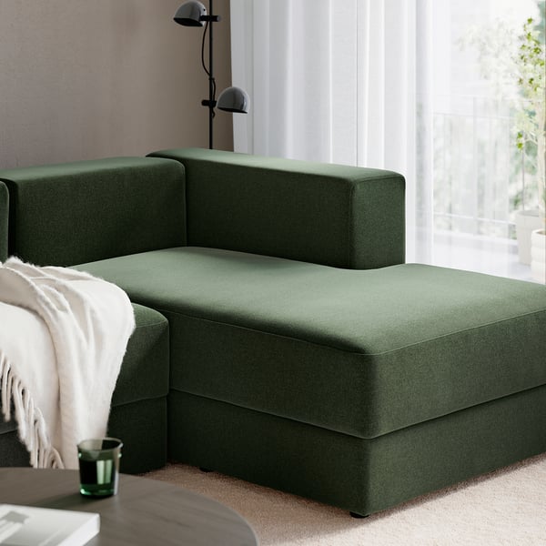 Moderne groene hoekbank met opbergpoef en vloerlamp, knus en praktisch voor woonkamers.