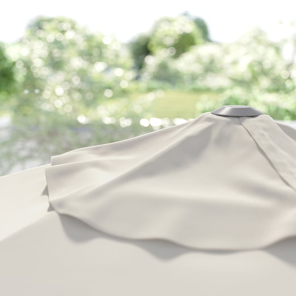 Close-up van lichtbeige JOGGESÖ parasols afgeronde bovenkant, gesloten; Tegen groene bomen.
