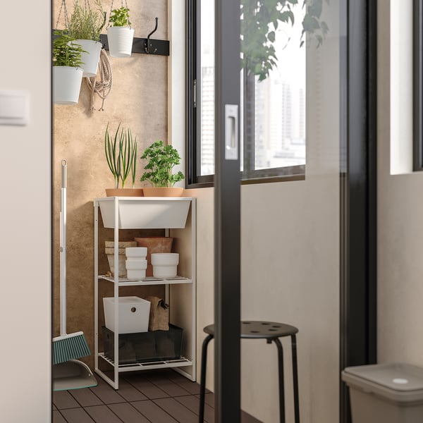 Witte JOSTEIN opbergplank met planten, containers, binnenshuis bij een raam, duurzaam staal.