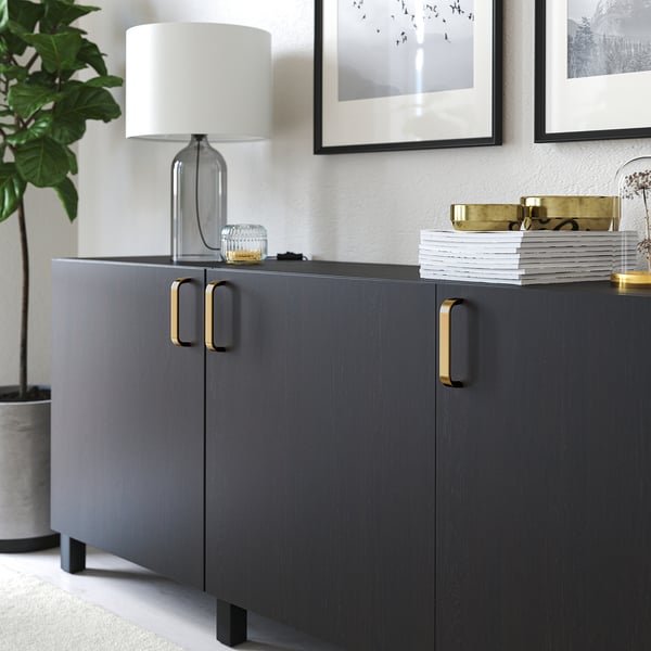 Moderne kast met gouden handvatten en een tafellamp erop. De handvatten zorgen voor een goede grip voor gemakkelijk openen.