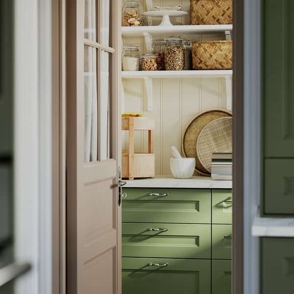 Keukenplank met groene KANELMOTT-mand met fruit en aardappelen, handgemaakt rotanontwerp.