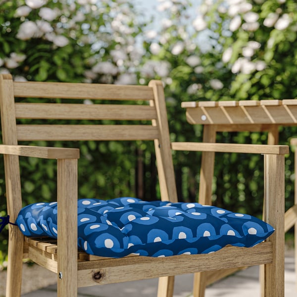 Houten parkbank met blauw en wit patroon rond kussen.