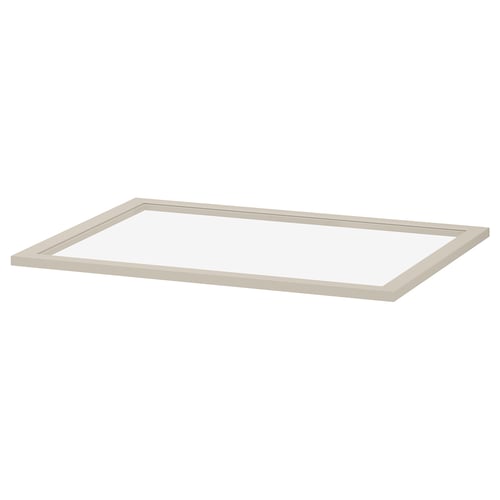 Een KOMPLEMENT glazen plank in beige. Het heeft een rechthoekige vorm met een frame van vezelplaat en een centrum van gehard glas, ontworpen voor het opbergen van kledingkasten.