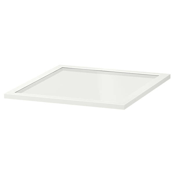 Een witte KOMPLEMENT glazen plank van ikea. Het rechthoekige, met een plat, transparant glazen oppervlak omlijst in wit.