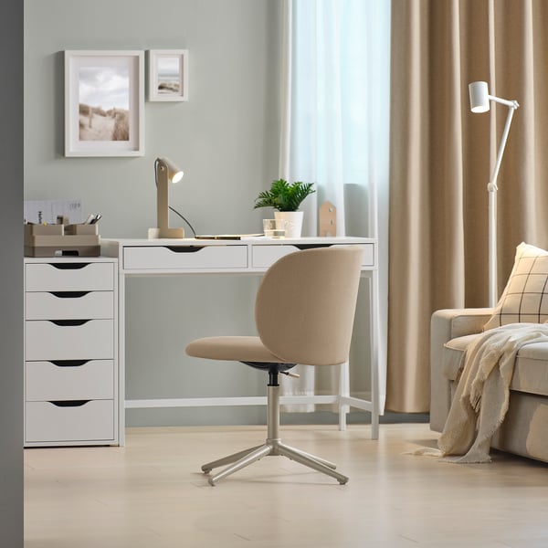 Minimalistisch thuiskantoor met KRYLBO stoel, bureau, lade, bank, lamp. Lichte houten vloer, pastelgroene muur.