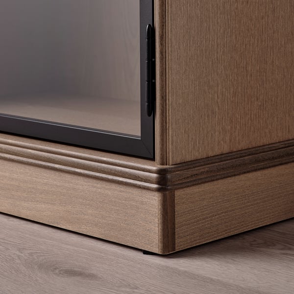 Elegante LANESUND-kast met stevig houten onderstel en glazen deuren, die getuigt van fijn vakmanschap.