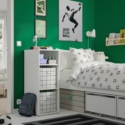 Kinderkamer met groene muren, een wit bed, voetbaldecoratie en een witte LASTARE-opslagruimte in de buurt.