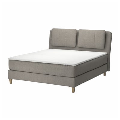 Modern grijs boxspringbed met schuin hoofdeinde, bekleed met gerecycled polyester, voorzien van verwijderbare kussens.