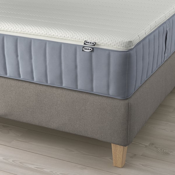 IKEA lilfjallet boxspringbed: grijs gestoffeerd bedframe met houten poten, twee matrassen tentoongesteld, met afneembare, machinewasbare hoezen.