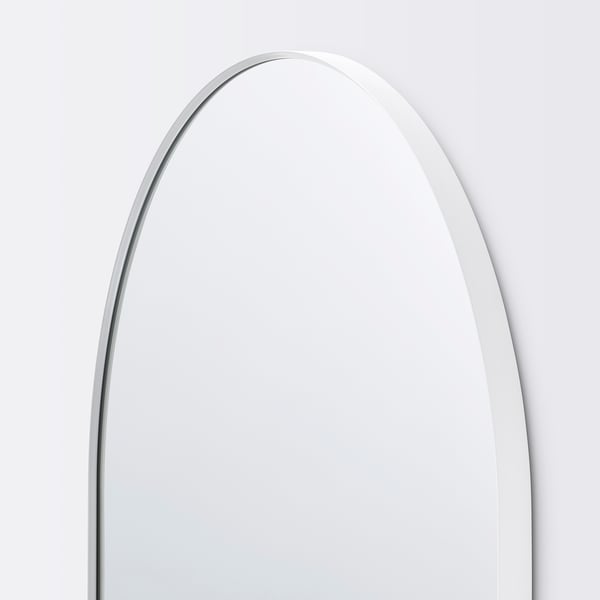 Boogvormige spiegel met strakke, witte lijst; reflecterend oppervlak ongerept, hoeken afgerond; Minimalistisch, elegant ontwerp.