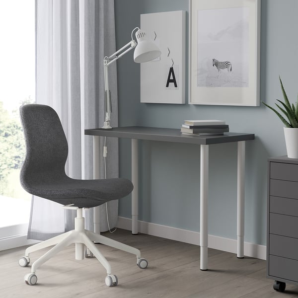 Minimalistisch thuiskantoor met LINNMON bureau, stoel, lamp en kunstafdrukken.