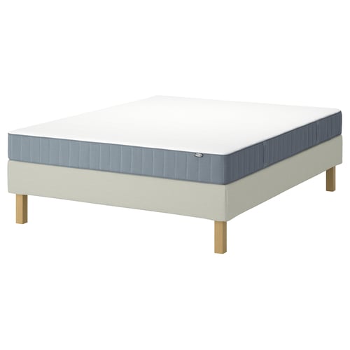 IKEA LYNGÖR bedbasis en matras in wit en blauw, met houten poten en een wit matras met blauwe zijkanten en hoeken.