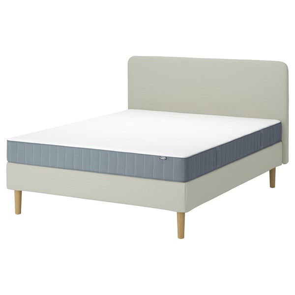 Lichtgekleurd bed met blauwgrijs matras en zacht hoofdeinde, modern minimalistisch ontwerp.