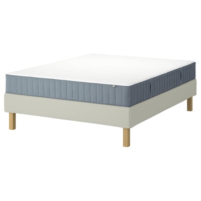 IKEA LYNGÖR bedbasis & valevåg blauwgrijs matras. De basis is beige met lichte houten poten. Het matras heeft 5 comfortzones.
