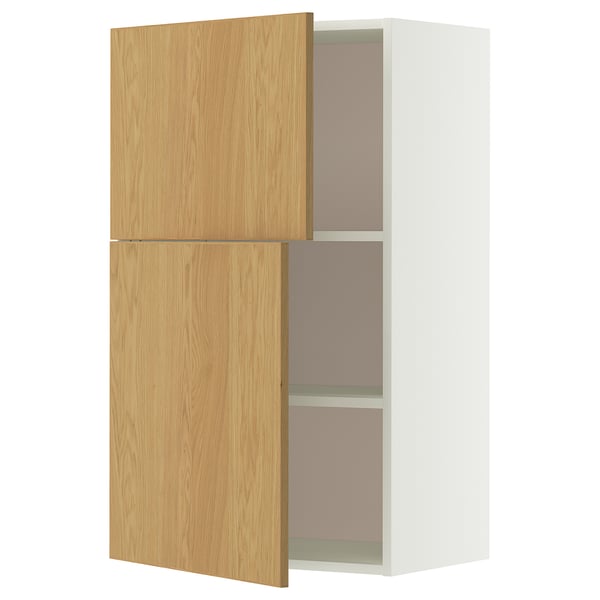 Een witte en lichthouten kast. Het heeft twee verstelbare planken en een deur met eiken fineer.