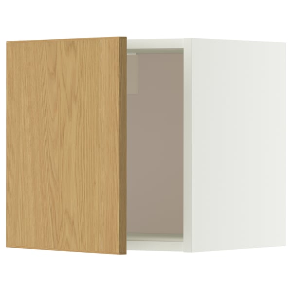 Een witte en lichte houten METOD wandkast met een deur die iets open staat, waardoor glazen planken aan de binnenkant zichtbaar zijn.