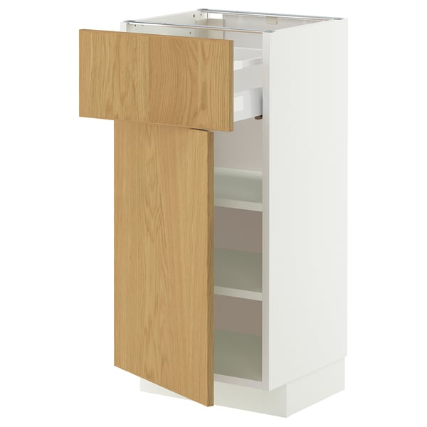 Een witte METOD opbergkast met een deur van eikenfineer die op een kier staat en aan de binnenkant verstelbare planken onthult.