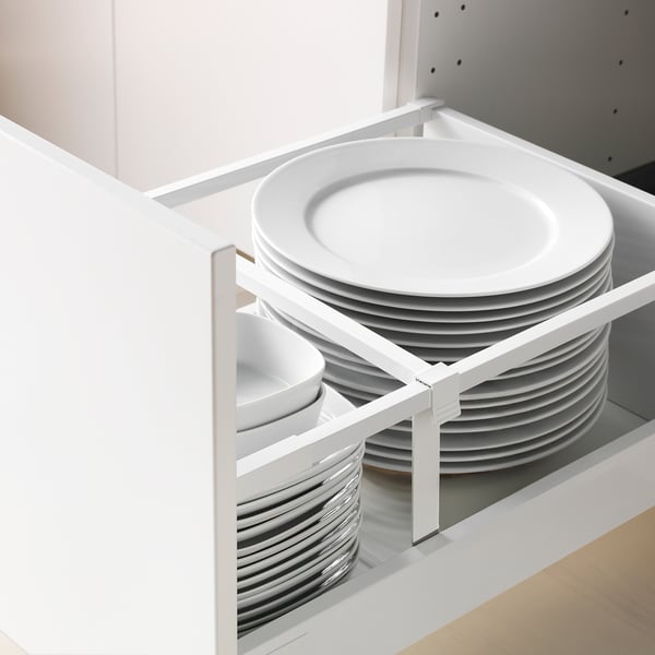 Keukenlade-organizer met gestapelde witte borden en kommen, onderdeel van het METOD-systeem.