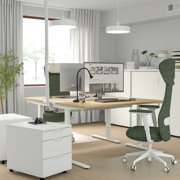 Moderne kantooropstelling met in hoogte verstelbaar MITTZON-bureau, groene ergonomische grönfjäll-stoel, monitor en wit opbergmeubel.