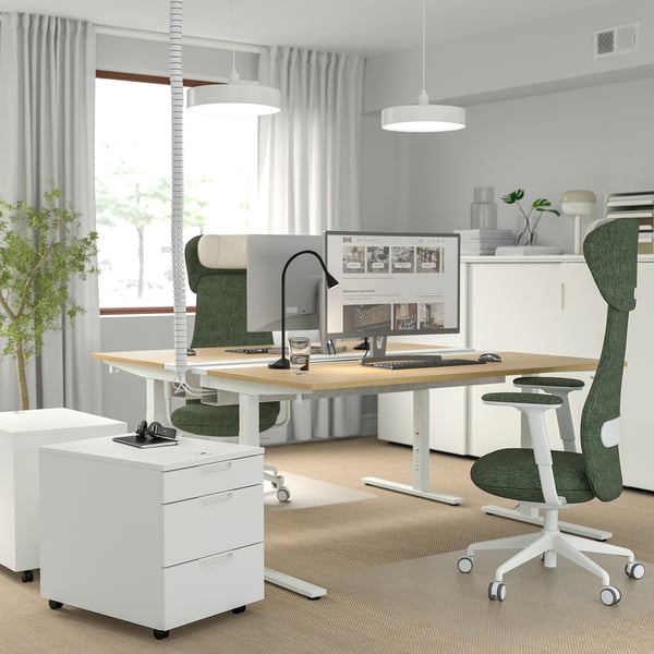 Moderne kantooropstelling met MITTZON wit in hoogte verstelbaar bureau, groene stoel. Minimalistisch design met veel ruimte.
