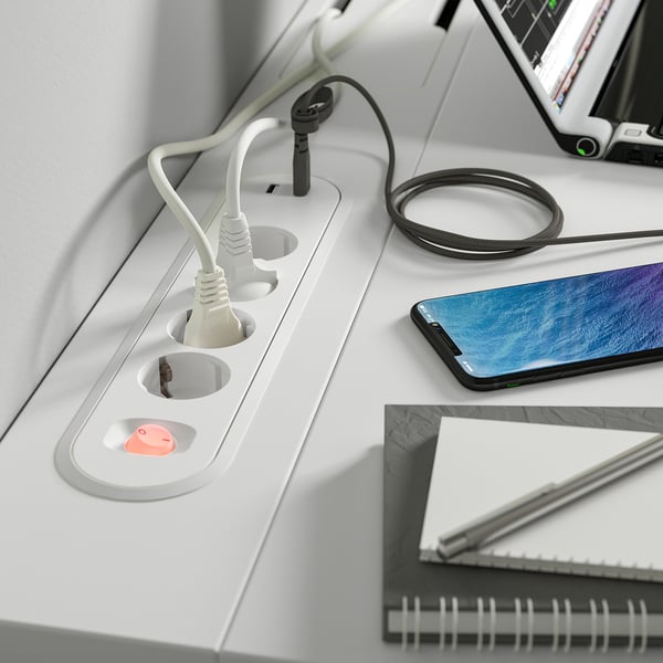 Bureau met oplaadtechnologie: telefoon, tablet, notebook.