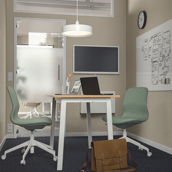 Kleine MITTZON vergadertafel met groene stoelen, laptop en witte wanden. Perfect voor compacte ruimtes.