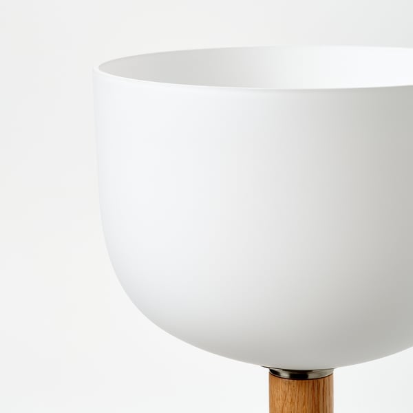 Moderne vloerlamp met een strakke witte kap en houten voet, met helder, verstelbaar licht.