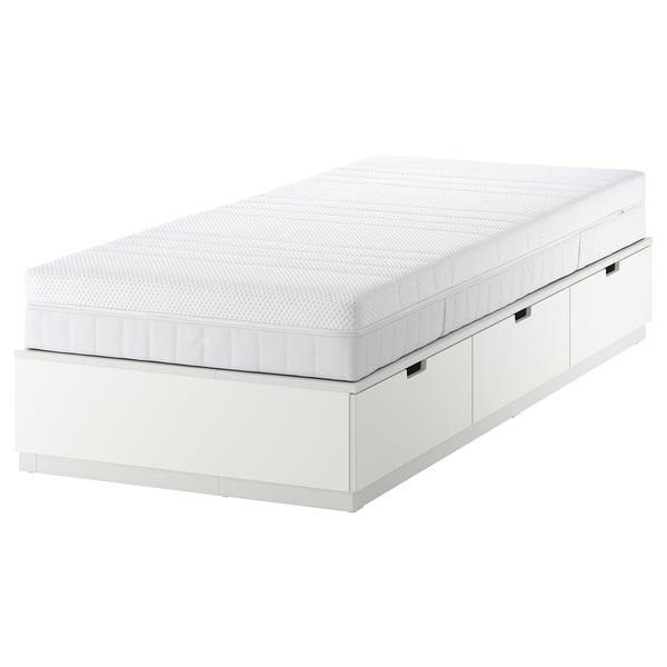 Een wit NORDLI bedframe met drie lades en een schuimmatras op een witte achtergrond.