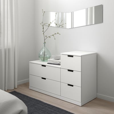 Moderne witte NORDLI kist met 6 lades en plantenvaas erop.