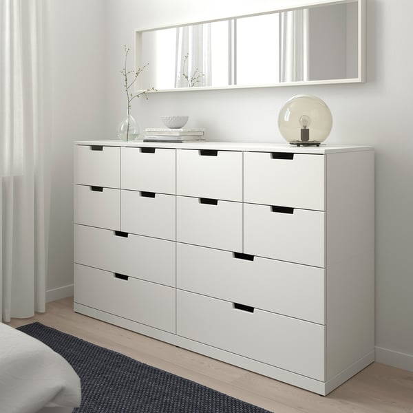 NORDLI wit dressoir met 6 lades en moderne handgrepen, lampdecor, hoog tegen de muur.