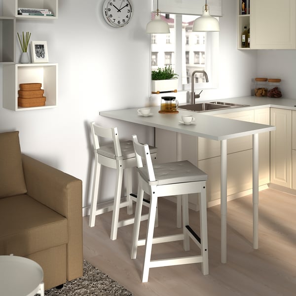 Kleine moderne keuken met witte stoelen en aanrecht.