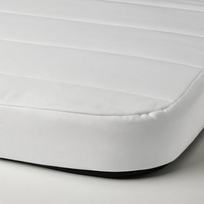 Een close-up van een witte schuimmatras, met een gladde, bedekte oppervlakte en stevige textuur.