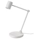 Een witte NYMÅNE tafellamp met een verstelbare arm en een draadloze oplader op de voet.