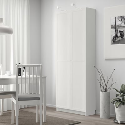 OXBERG kledingkast met dubbele deuren bij het raam in een lichte kamer.