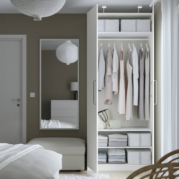 Moderne slaapkamer met open kledingkast, kleding en georganiseerde opbergers, lichtgrijs en wit.