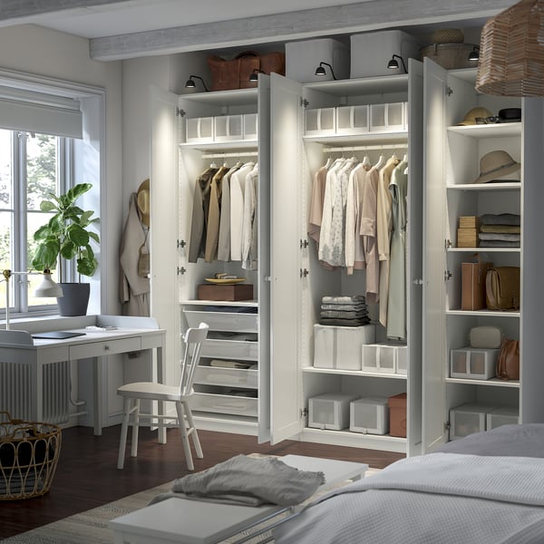 Een goed georganiseerde kledingkast met planken en lades met netjes opgevouwen kleding en accessoires.