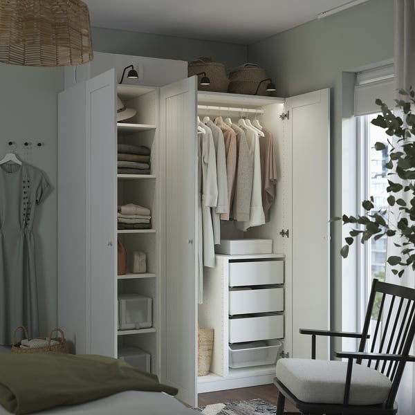 Open witte kledingkast met kleding en manden erin, gebaseerd op PAX-systeem.