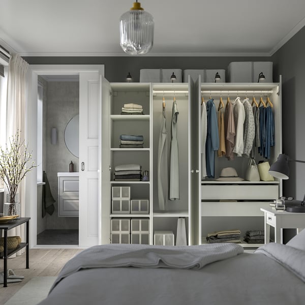 Nette slaapkamer met open kledingkast met georganiseerde kleding, planken en lades, met verstelbare poten en geïntegreerde verlichting.