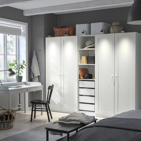Kamer met grote PAX kledingkast, stoel, bureau en bed.
