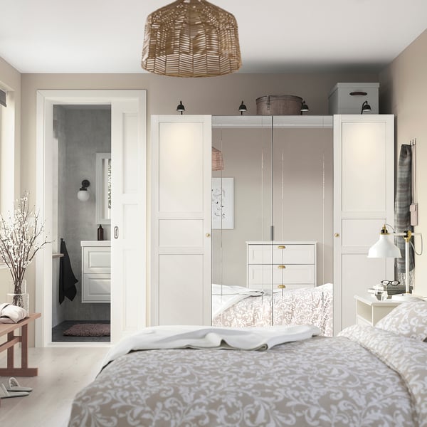 Slaapkamer met hoge, brede PAX-kast, spiegeldeuren, aangrenzende donkere badkamer.