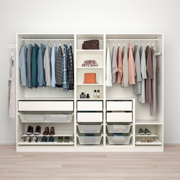 Een witte PAX-kledingkast organiseert kleding, schoenen en accessoires met planken, lades en hangruimte.