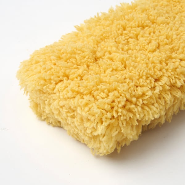 Een close-up van een zachte, gele PEPPRIG microvezel stofdoeknavulling, met het dichte, getextureerde oppervlak, ideaal om af te stoffen.